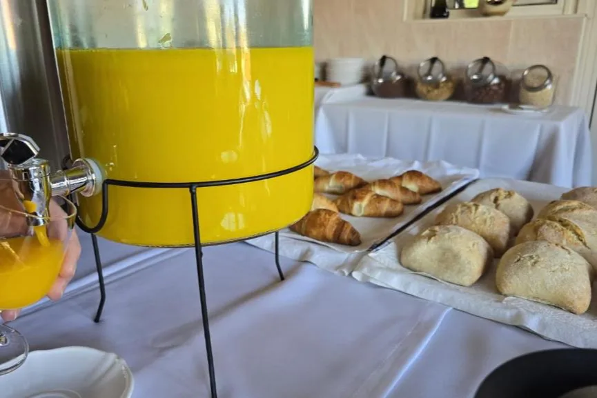 Sumo de laranja e pão do dia
