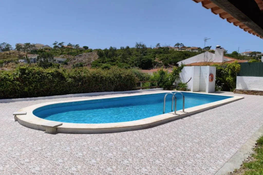 A piscina oval, vista da casa